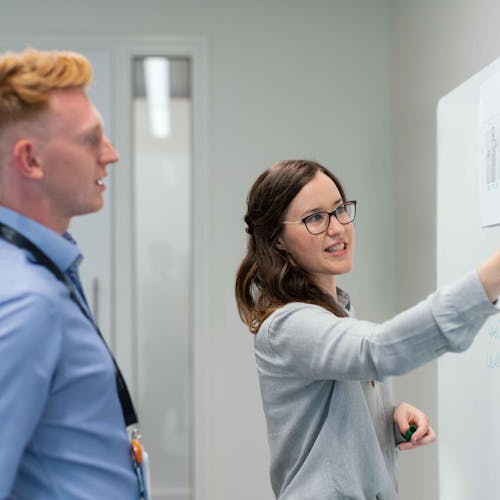 Person using a pen to cross a task off a productivity paper card.