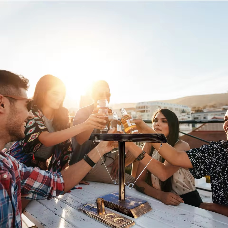Groupe d'amis jouant à un jeu de l'anneau autour d'une table en plein air
