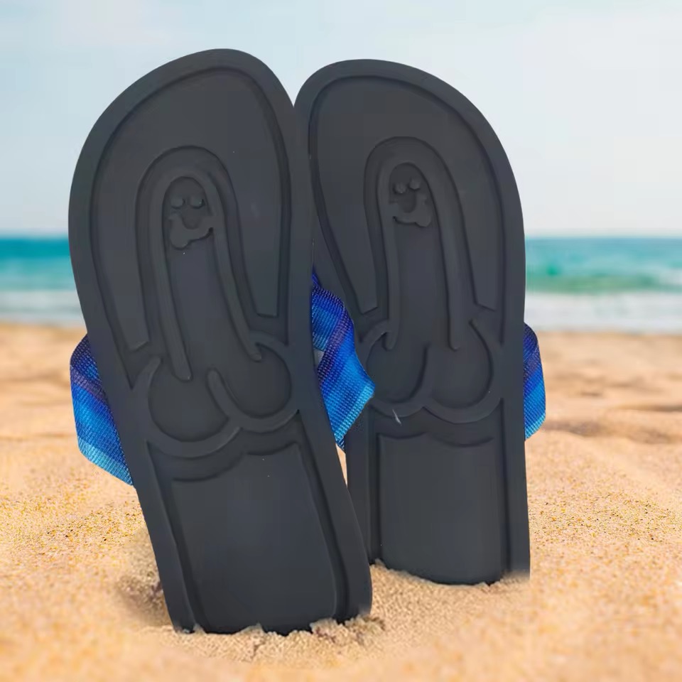 Paire de tongs avec une empreinte humoristique sur le sable, vue en bord de mer